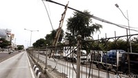 Tangga kayu digunakan untuk menyangga kabel yang melintang di Jalan Gunung Sahari.