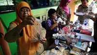 Sejumlah siswa sekolah dasar 01 mengamati petugas Badan Pengawasan obat dan Makanan (BPOM) yang mengambil sample jajanan Kantin sekolah di SD 01 Klender.