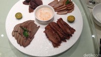 Cara unik memakannya adalah dengan mencelup daging bebek dengan saus. Kemudian taruh di lembaran seperti kulit lumpia. tambahkan lobak, gula pasir, timun, kol, dan bumbu lainnya (Radian/detikTravel)