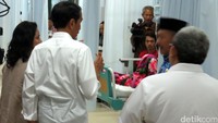 Jokowi dan Iriana berbincang dengan keluarga pasien.