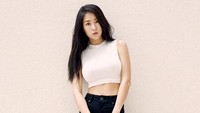 Berpose sambil memegang tas hitam, Soyu tampak seksi dengan crop top putih, hot pants hitam dan sandal gladiator hitam. (dok. Cosmopolitan Korea)