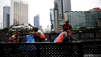 Pekerja memasang dan merapikan pot bunga yang baru dipasang taman tepi Bundaran HI, Jakarta Pusat, Jumat (18/3/2016).