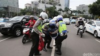 Polisi menggotong korban ke tepi jalan.