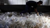 Salah seorang pekerja mengumpulkan botol plastik sebelum nantinya akan diolah di Perumahan Vida Bekasi, Minggu (20/03/2016).