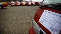 Para sopir taksi menempelkan taksinya dengan kertas dan spanduk berisi penolakan taksi online berpelat hitam.