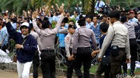 Polisi berusaha menenangkan massa.