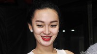 Ia tampak kenakan busana bernuansa putih dan memoles bibirnya dengan lipstik merah menyala. Pool/Noel/detikFoto.