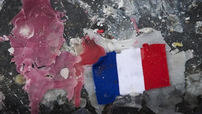 A picture shows a small French flag on candle wax on the Place de la Republique in Paris on December 2, 2015, at a memorial for victims of coordinated attacks in and around Paris on November 13. 

Islamic State jihadists claimed a series of coordinated attacks by gunmen and suicide bombers in Paris that killed 130 people and wounded hundreds more in scenes of carnage at a concert hall, restaurants and the national stadium.
 / AFP / JOEL SAGET