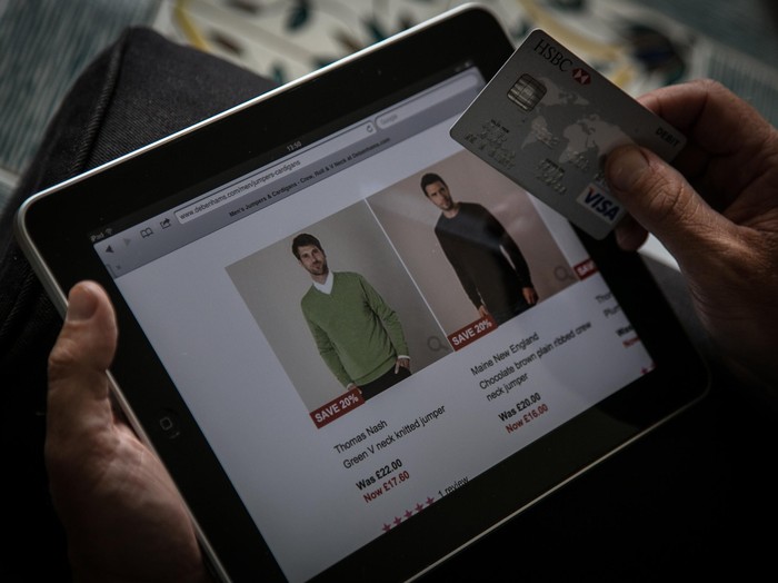 BRISTOL, UNITED KINGDOM - AUGUST 11:  In this photo illustration a man uses a credit card to buy something online on August 11, 2014 in Bristol, United Kingdom. This week marks the 20th anniversary of the first online sale. Since that sale - a copy of an album by the artist Sting - online retailing has grown to such an extent that it is now claimed that 95 percent of the UK population has shopped online and close to one in four deciding to shop online each week.  (Photo Illustration by Matt Cardy/Getty Images)