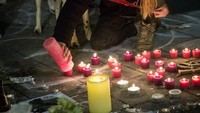 Mereka menyalakan lilin di depan bandara. Aurore Belot/AFP.