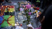 Seorang wanita membawa setangakai bunga. AFP/Kenzo Tribouillard.