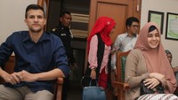 Ibu dua anak itu tampak tersenyum di ruang sidang.