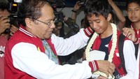 Menko Maritim Rizal Ramli mengalungkan rangkaian bunga kepada salah satu siswa.