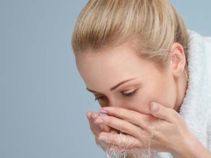 cuci muka Young woman washing her face