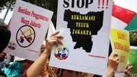 Demonstran membawa poster-poster tuntutan.