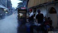 Seorang pedagangan sate menjajakan daganganya.
