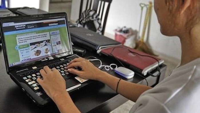 TO GO WITH Lifestyle-Asia-Internet-economy-retail,FOCUS by Simin WangThis photo taken on April 26, 2011 shows an Internet user surfing a group-buying online coupon website in Singapore. Innovative 