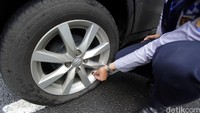 Petugas melakukan pencabutan pentil mobil  yang parkir sembarangan.