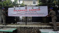 Petugas Sat Pol PP juga memasang spanduk larangan parkir disepanjang jalan tersebut.
