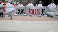 Demonstran membawa seng bertuliskan Coal Kills Us.