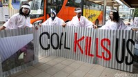 Demonstran membentangkan seng bertuliskan Coal Kills Us di depan Kedubes Jepang, Jakarta.