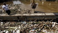 Satuan Petugas dari Dinas Kebersihan DKI Jakarta membersihkan sampah yang menyangkut di jembatan kampung Melayu, Jakarta, Minggu (3/4/2016).