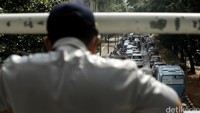 Petugas Dinas Perhubungan DKI Jakarta, memantau kemacetan di Jalan Jenderal Sudirman, Jakarta, dari atas Jembatan Penyeberangan Orang (JPO).