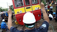 Petugas berusaha mengevakuasi kereta. Sementara penyebab anjloknya kereta itu masih belum diketahui.