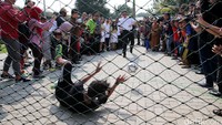 Ahok menendang bola saat mencoba lapangan futsal di RPTRA Dharma Suci.