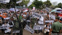 Daftar rumah dinas yang akan digusur digantungkan pada pohon kering yang dibawa pendemo.