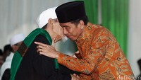 Presiden Jokowi cipika-cipiki dengan tokoh senior PPP KH Maimun Zubair atau Mbah Moen saat tiba di Asrama Haji, Pondok Gede.