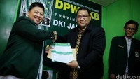 Jurnalis yang juga menjabat Pemimpin Umum RM Online Teguh Santosa (tengah) menunjukan berkas pendaftaran yang harus diisi.