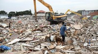 Alat berat terus bekerja membersihkan puing-puing bangunan.