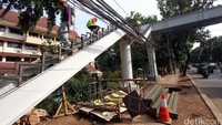 Pekerja menyelesaikan pembangunan Jembatan Penyeberangan Orang (JPO) di kawasan Tebet, Jakarta, Selasa (12/4/2016).