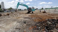 Sebuah ekskavator sibuk meratakan tanah.