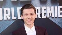Tom Holland yang berperan sebagai Spider-Man tersenyum lebar saat berpose di depan kamera. Jesse Grant/Getty Images for Disney/detikFoto.
