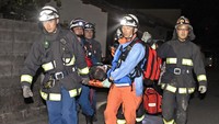 Petugas mengevakuasi korban luka menggunakan tandu. Kyodo/Reuters/detikFoto.