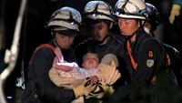 Bayi ini ditemukan dalam keadaan hidup dan tidak mengalami luka sedikitpun dari reruntuhan rumah yang roboh di wilayah Mashiki. Reuters/Kumamoto Prefectural Police/Handout via Reuters.