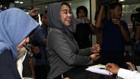 Perempuan berusia 35 tahun itu tampak mengenakan setelan kerudung dan pakaian serba abu-abu.