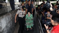 Beberapa polisi membantu mengantarkan Kartini menuju mobilnya.