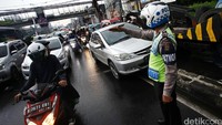 Seorang polisi berusaha mengurai kemacetan.