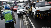 Petugas berusaha mengevakuasi mobil tersebut.