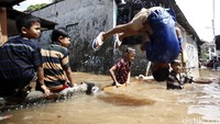 Anak-anak tampak asik berenang saat banjir.