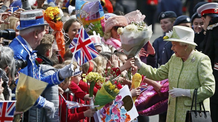 Britains Queen Elizabeth receives flowers and cards from well-wishers during a walkabout to celebrate her 90th birthday, in Windsor, Britain April 21, 2016.       REUTERS/Stefan Wermuth