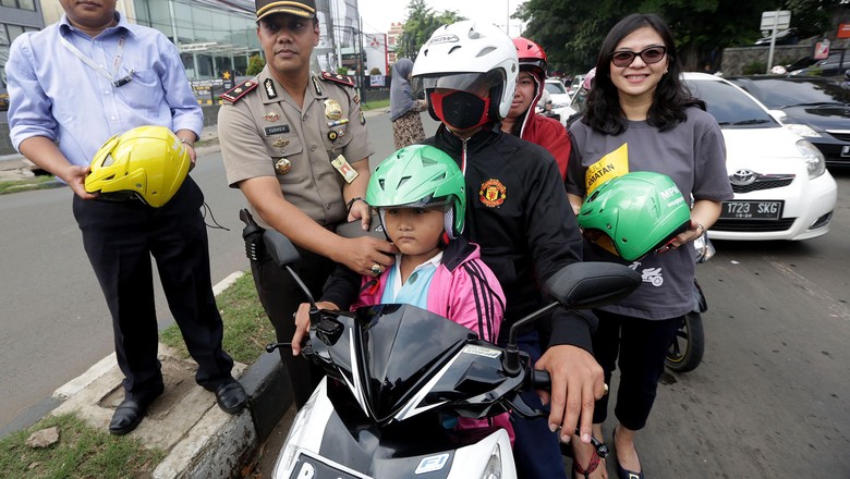 Aksi peduli keselamatan berlalulintas digelar di Duren Sawit, Jakarta Timur, Rabu (24/4). Aksi dilakukan dengan cara membagikan helm pada pemotor yang membonceng anak. Foto: Pool Aksi peduli keselamatan berlalulintas digelar di Duren Sawit, Jakarta Timur, Rabu (24/4). Aksi dilakukan dengan cara membagikan helm pada pemotor yang membonceng anak. Foto: Pool
