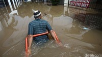 Warga beraktivitas di tengah banjir yang melanda pemukiman mereka di Kemang Timur, Jakarta, Kamis (21/04/2016).