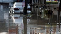 Sebuah mobil teronggok akibat mogok terendam banjir.