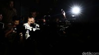 Zaki yang dikerumuni sejumlah wartawan berjalan menuju mobilnya.