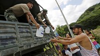 Beberapa warga menerima bantuan air minum dari tentara Ekuador. Henry Romero/Reuters/DetikFoto.