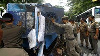 Petugas Satpol PP DKI Jakarta Selatan membongkar warung yang berada di atas saluran air di kawasan Duren Tiga Jakarta, Rabu (27/4/2016).